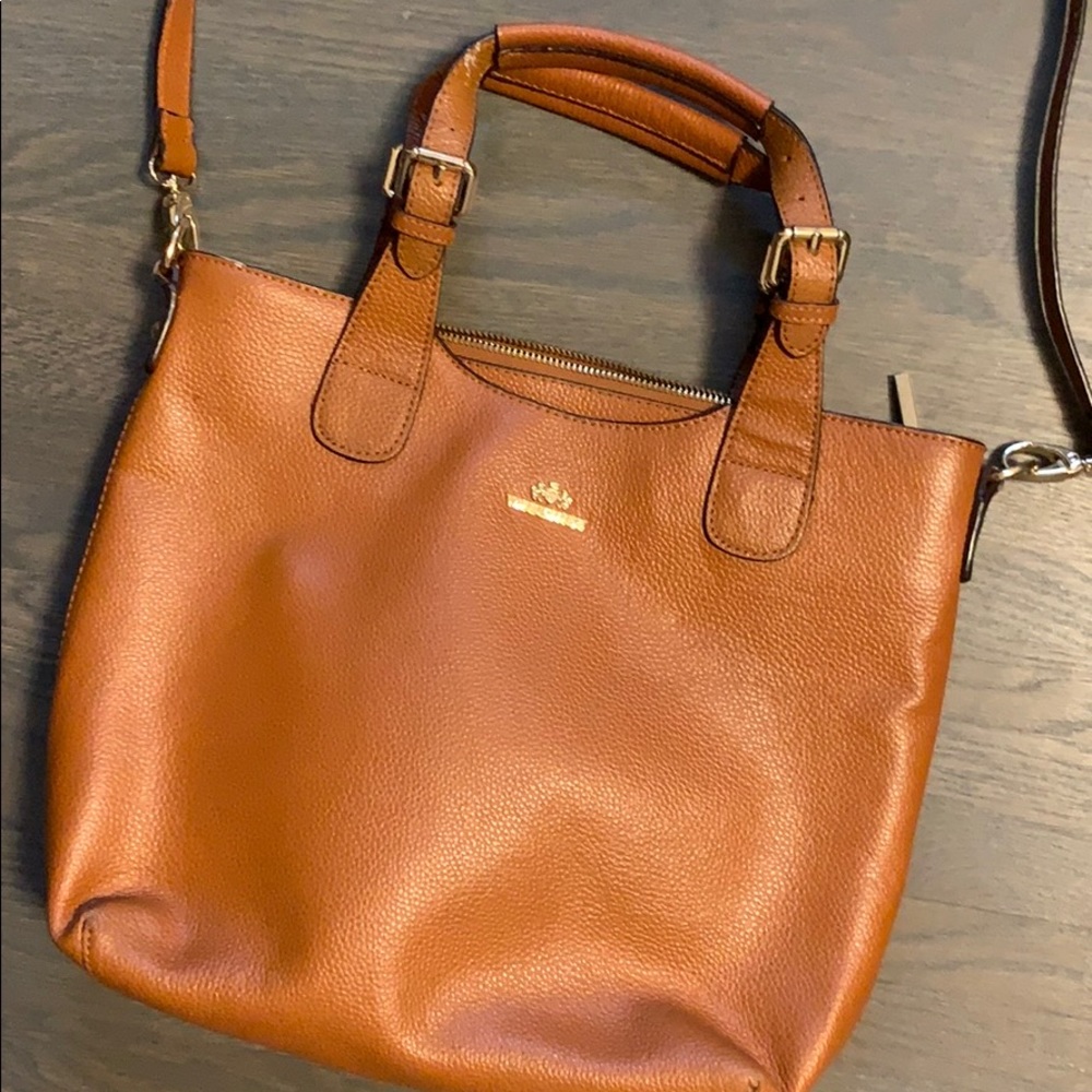 Witches cross shoulder woman’s bag.